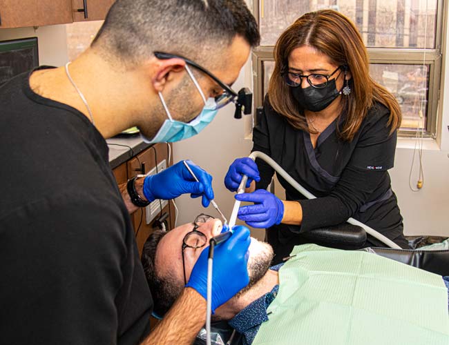Emergency Dentist Dr. Justin Bral Working With His Assistant