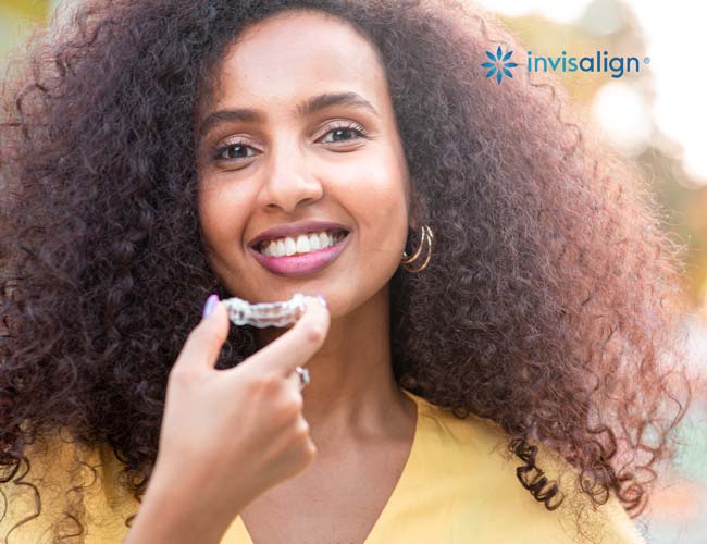 Girl Holding an Invisalign Tray by Her Mouth